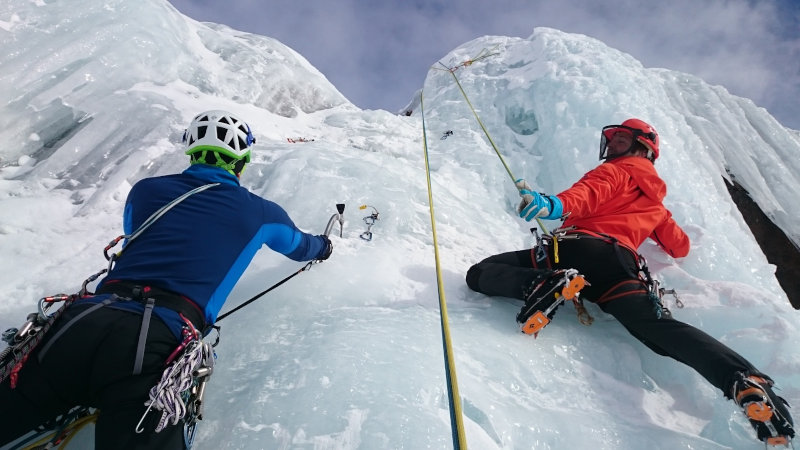 Zwei Menschen klettern in ihrer Hardshelljacke am Eis