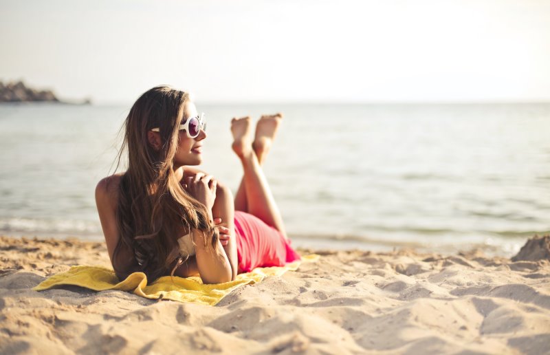 After Sun im Test als Pflege nach dem Sonnenbaden Frau nimmt Sonnenbad am Strand