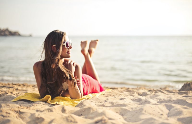 Frau nimmt Sonnenbad am Strand