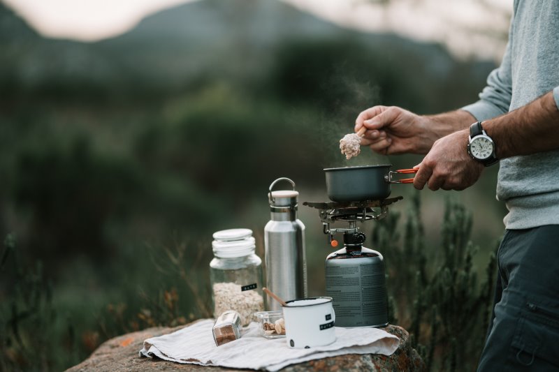 Campingkocher im Test, der Gaskocher Jemand kocht auf einem Gaskocher