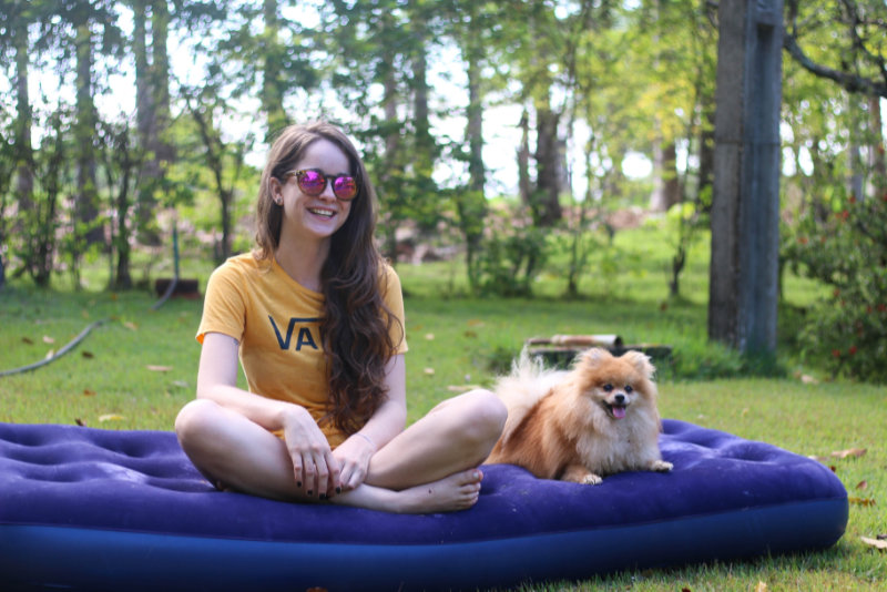 Hund und Mädchen sitzen auf einer Luftmatratze