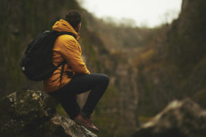 Ein Mann schaut in die Berge in seiner Hardshelljacke