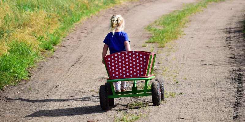 Ein Kind, das einen Bollerwagen zieht.